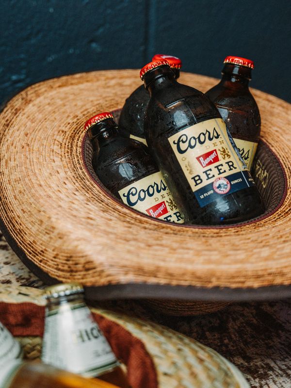 A cowboy hat holding a handful of ice cold beers